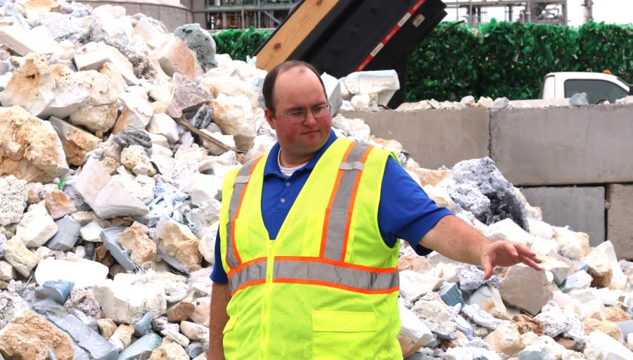 <strong><em>Spencer Tidwell, a chemical engineer for Eastman Chemical Company, stands in front of “chunk” waste plastic purged from a mechanical recycling facility at Eastman’s mixed plastics processing facility in Kingsport, Tenn. (Photo: WJHL) </em></strong>