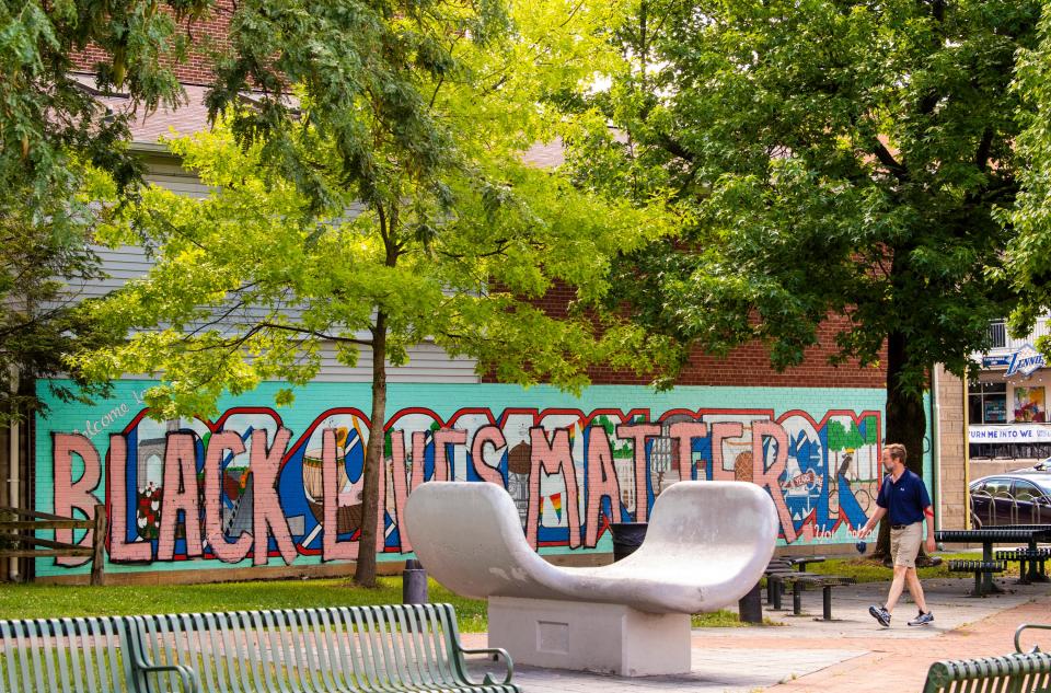 A man walks past the “You Belong Here” mural in People’s Park Tuesday, June 23, 2020.