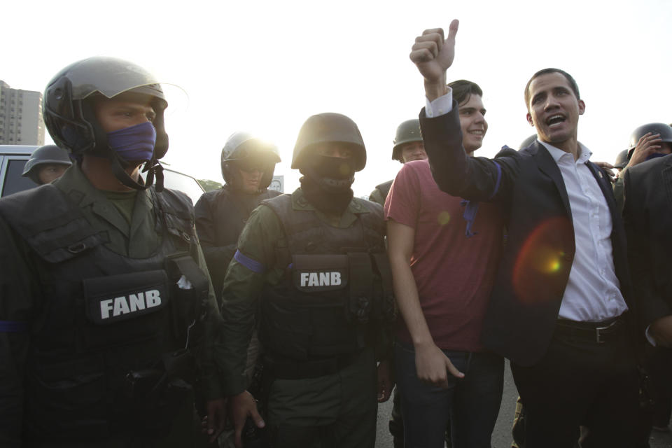 El dirigente opositor y autoproclamado presidente venezolano Juan Guaidó habla junto a soldados frente a la base aérea La Carlota, Caracas, martes 30 de abril de 2019. (AP Foto/Boris Vergara)