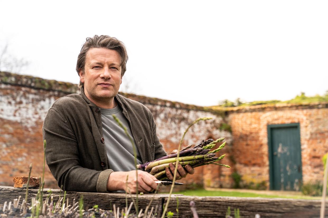 Pictured: Jamie Oliver holding.asparagus.