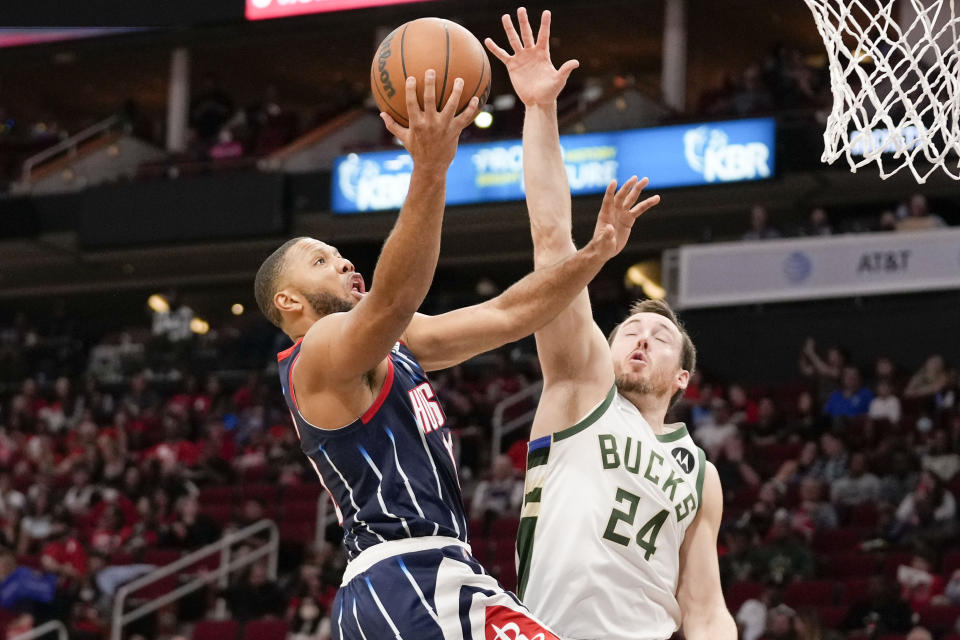 Houston Rockets guard Eric Gordon, left, drives to the basket as Milwaukee Bucks guard Pat Connaughton defends during the first half of an NBA basketball game, Friday, Dec. 10, 2021, in Houston. (AP Photo/Eric Christian Smith)