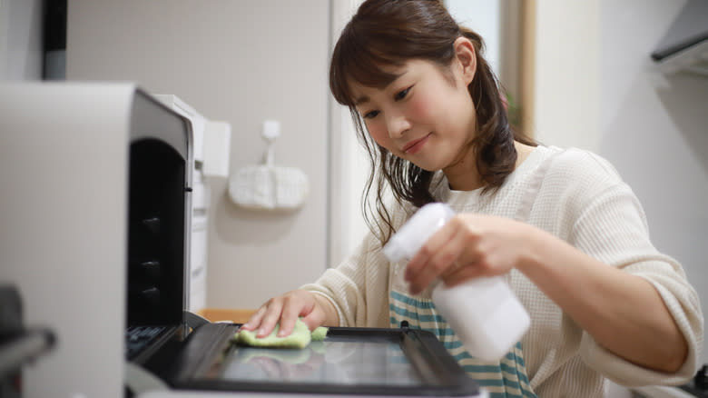 Person cleaning a toaster oven