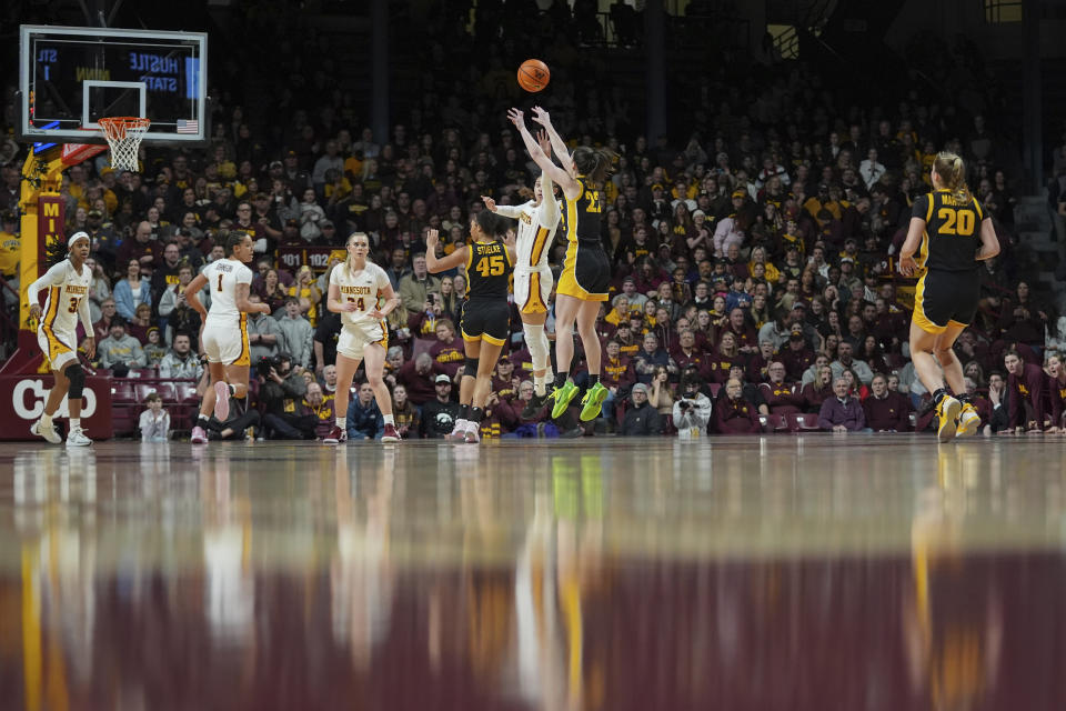 Iowa guard Caitlin Clark (22) shoots over Minnesota guard Amaya Battle during the first half of an NCAA college basketball game Wednesday, Feb. 28, 2024, in Minneapolis. (AP Photo/Abbie Parr)