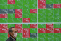 A man walks by an electronic stock board of a securities firm in Tokyo, Wednesday, May 19, 2021. Asian shares fell Wednesday, tracking a decline on Wall Street led by big technology stocks. (AP Photo/Koji Sasahara)