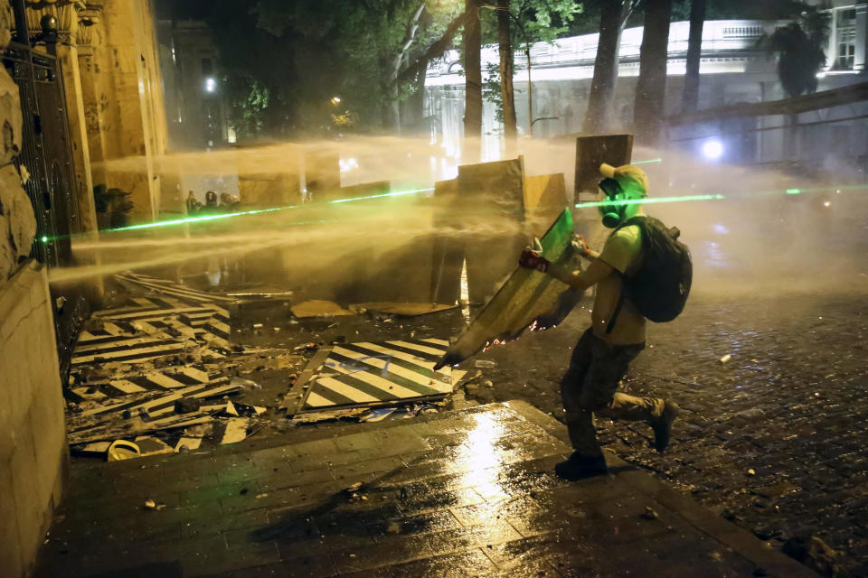 Police use water cannons and tear gas against demonstrators during an opposition protest against "the Russian law" near the Parliament building in Tbilisi, Georgia, on Wednesday, May 1, 2024. Protesters denounce the bill as "the Russian law" because Moscow uses similar legislation to stigmatize independent news media and organizations critical of the Kremlin. (AP Photo/Zurab Tsertsvadze)