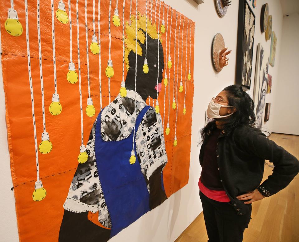 Seema Rao, deputy director & chief experience officer Akron Art Museum, looks at Haske, a single use plastic and embroidery work by artist Rufai Zakari, and it is one of the most Instagramble works in the the museum. [Mike Cardew/Akron Beacon Journal] Photo taken Thurssday. Oct. 21, 2021. 