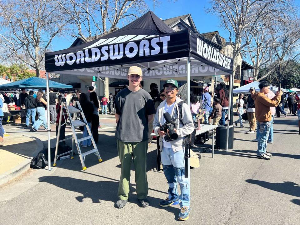 World’s Worst Expo co-owner Casey Mann, left, with videographer Tony Jelks-Tran. FIT CHECK: Mann is wearing a World’s Worst trucker hat, a thrifted ’90s t-shirt, ’80s military pants and Salehe Bembury Crocs.