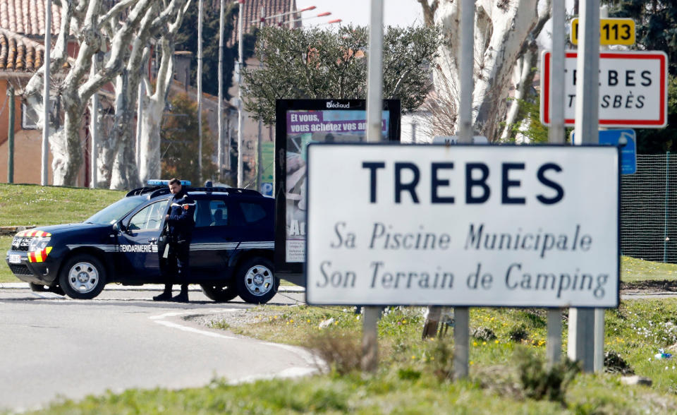 <p>A gendarme secures the perimeter near a roadsign welcoming visitors to Trèbes, where a gunman claiming allegiance to the Islamic State (IS) holding hostages in Trebes, southern France, 23 March 2018. French police are launching a raid on the supermaket where a gunman that allegedly pledged alliance to the IS is holding hostages. Police says at least two people died and dozens were injured in Trebes near Carcassonne. (Photo: Guillaume Horcajuelo/EPA-EFE/REX/Shutterstock) </p>