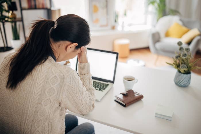 A woman looking tired at her desk