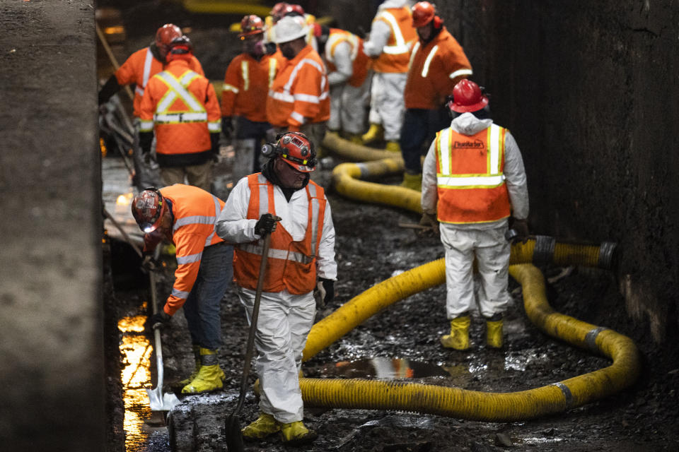 Amtrak workers perform tunnel repairs to a partially flooded train track bed, Saturday, March 20, 2021, in Weehawken, N.J. With a new rail tunnel into New York years away at best, Amtrak is embarking on an aggressive and expensive program to fix a 110-year-old tunnel in the interim. (AP Photo/John Minchillo)