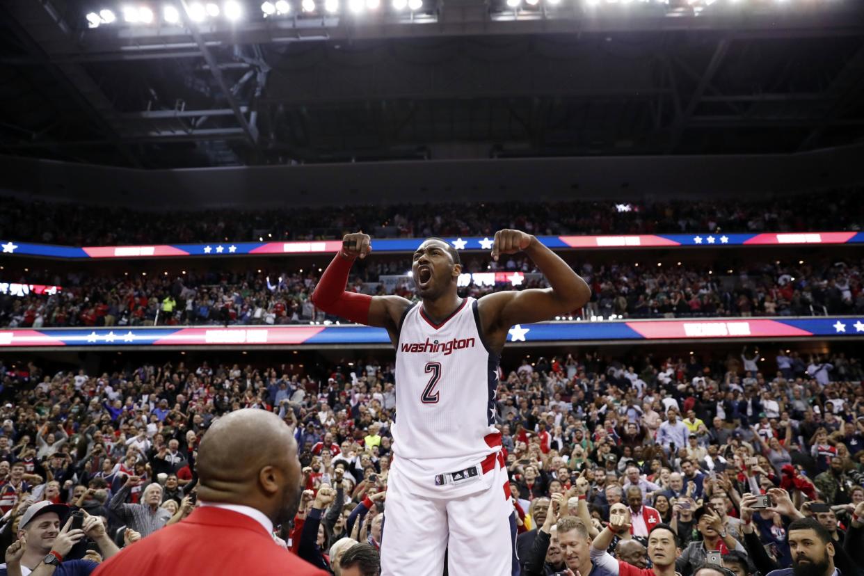 An emotional John Wall roars as he celebrates the Wizards' season-extending Game 6 win. (AP)