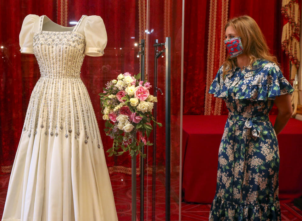 WINDSOR, ENGLAND - SEPTEMBER 23: Princess Beatrice poses alongside her wedding dress as it goes on display at Windsor Castle on September 23, 2020 in Windsor, England. Princess Beatrice and Edoardo Mapelli Mozzi married on July 18, 2020 in Windsor. (Photo by Steve Parsons - WPA Pool/Getty Images)