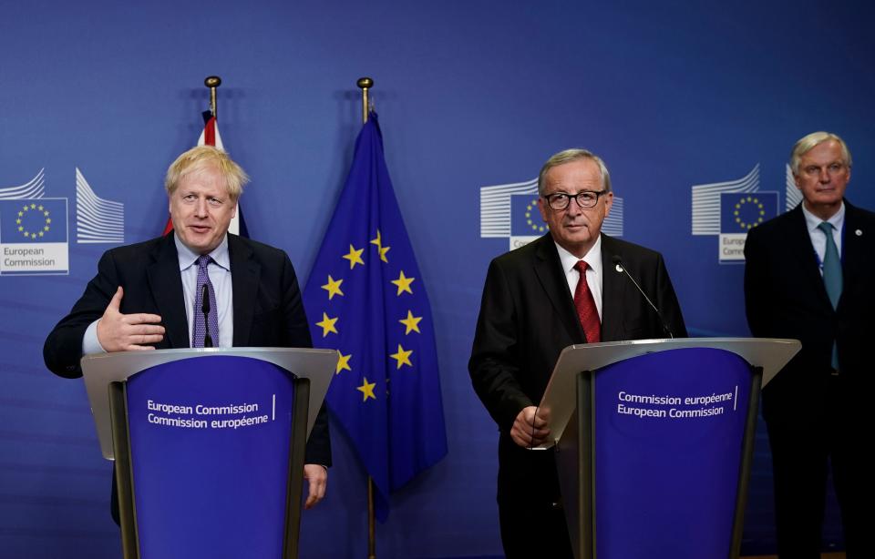 British Prime Minister Boris Johnson (L) is watched by President of the European Commission Jean-Claude Juncker (C) and EU chief Brexit negotiator Michel Barnier (R) as they address a press conference at a European Union Summit at European Union Headquarters in Brussels on October 17, 2019. (Photo by Kenzo TRIBOUILLARD / AFP) (Photo by KENZO TRIBOUILLARD/AFP via Getty Images)