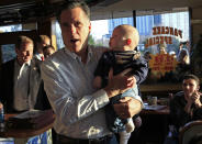 Republican presidential candidate and former Massachusetts Governor Mitt Romney holds a baby as he greets diners at a restaurant during a campaign stop in Rosemont, Illinois, March 16, 2012. REUTERS/Jim Young