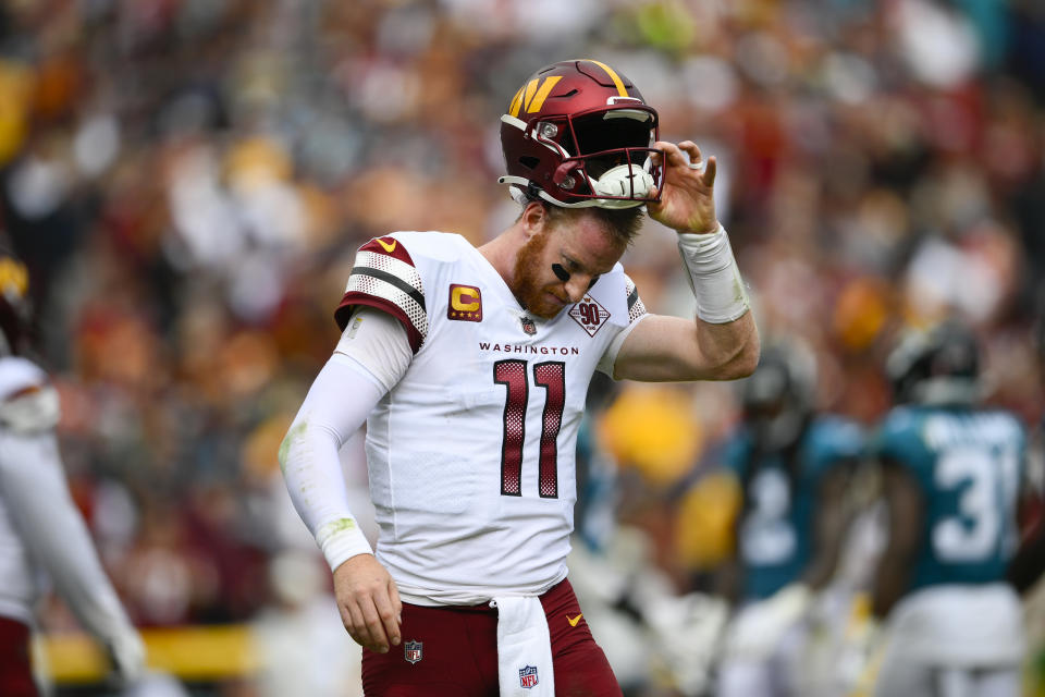 Washington Commanders quarterback Carson Wentz (11) taking off his helmet as he heads back to the sidelines during the second half of an NFL football game against the Jacksonville Jaguars, Sunday, Sept. 11, 2022, in Landover, Md. (AP Photo/Nick Wass)