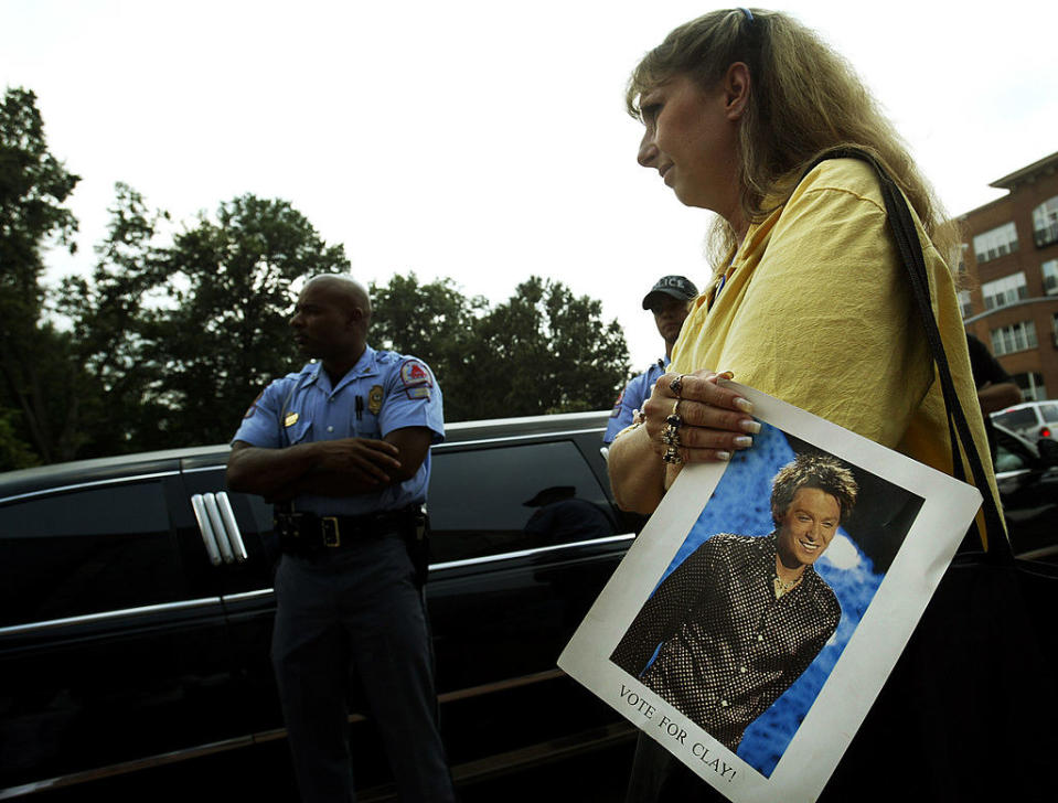 Woman holding a Clay Aiken poster next to a limo