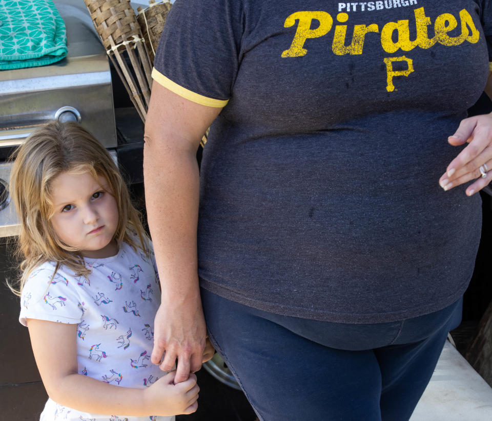 Jordyn Grier, 4, holds her mother's hand as her mother, Jennifer and other Saving Mercy residents, talked about the fear of getting evicted Friday morning.