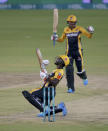 Peshawar Zalmi' Sherfane Rutherford, front, and Mujeeb Ur Rahman jublates after score level during a Pakistan Super League T20 cricket match between Quetta Gladiators and Peshawar Zalmi at the National Stadium, in Karachi, Pakistan, Friday, Feb. 26, 2021. (AP Photo/Fareed Khan)