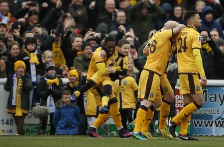 Britain Football Soccer - Sutton United v Leeds United - FA Cup Fourth Round - The Borough Sports Ground - 29/1/17 Sutton United's Jamie Collins celebrates scoring their first goal with team mates and a mascot Action Images via Reuters / Andrew Couldridge Livepic EDITORIAL USE ONLY. No use with unauthorized audio, video, data, fixture lists, club/league logos or "live" services. Online in-match use limited to 45 images, no video emulation. No use in betting, games or single club/league/player publications. Please contact your account representative for further details.