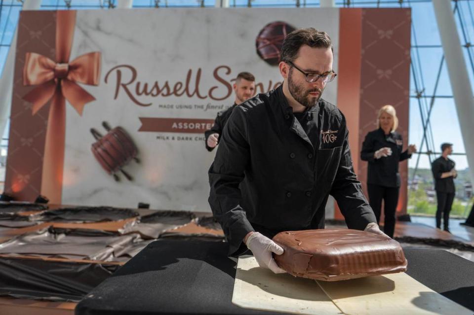 Mike Finn prepares to put a giant chocolate slab into a chocolate box during Russell Stover Chocolates attempt to break the Guinness World Record for the largest box of chocolate.