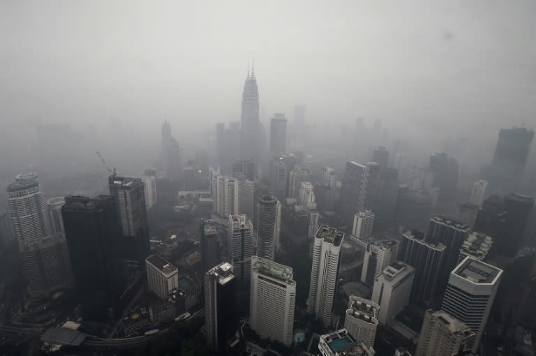 Malaysia's landmark Petronas Twin Towers (C) and other commercial buildings are shrouded in haze in Kuala Lumpur on September 13, 2015