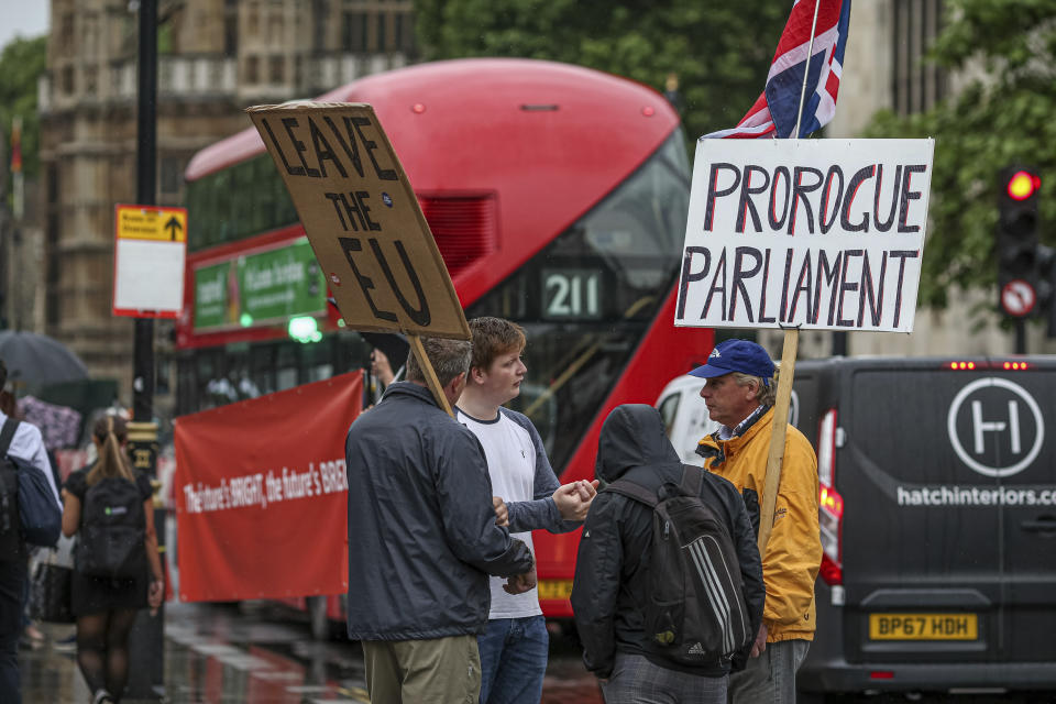 Pro-Brexit supporters hold placards as they demonstrate outside the British Houses of Parliament, meanwhile the British Conservative party leadership contenders run their leadership race in London Tuesday, June 18, 2019.  The result of an elimination vote will be announced Tuesday and Conservative Party lawmakers will continue to vote to eliminate leadership candidates over the coming days until the final two contenders will go to a postal ballot of party members. Banner at right calls for parliament to be prorogued, meaning to disband parliament to allow for a no-deal Brexit. (AP Photo/Vudi Xhymshiti)