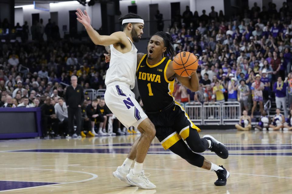Iowa guard Ahron Ulis, right, drives against Northwestern guard Boo Buie during the first half of an NCAA college basketball game in Evanston, Ill., Sunday, Feb. 19, 2023. (AP Photo/Nam Y. Huh)