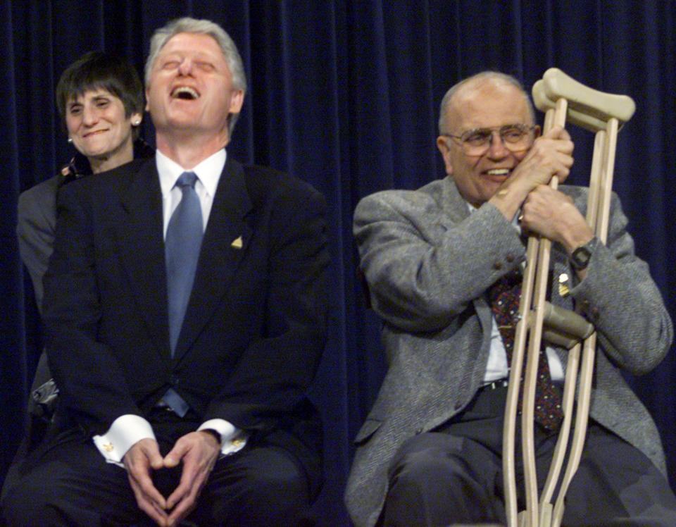 President Bill Clinton, sitting next to Dingell, laughs during a patients' bill of rights event in Washington, D.C.