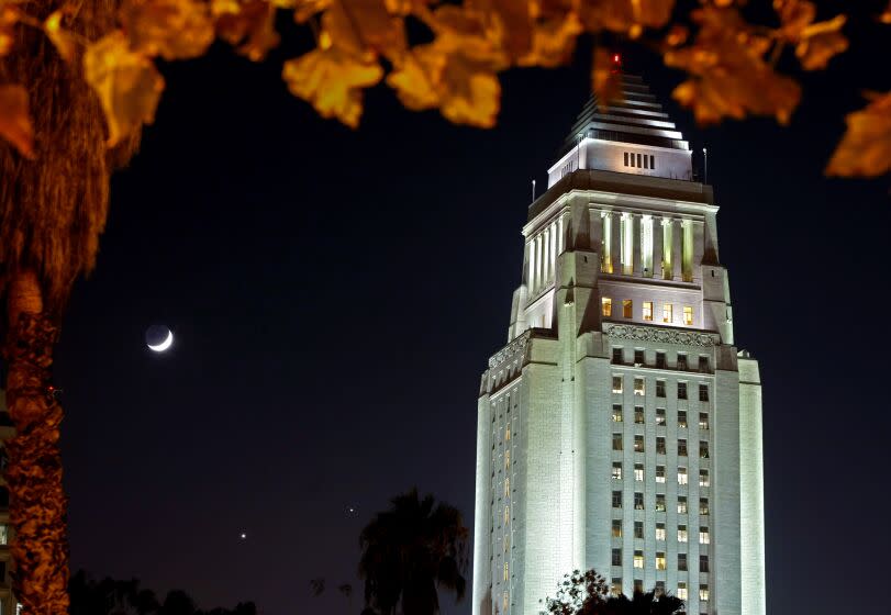 LOS ANGELES, CA. DECEMBER 1, 2008. A rare celestial conjunction of the waxing crescent moon, Venus and Saturn shine in the southern sky behind Los Angeles City Hall.