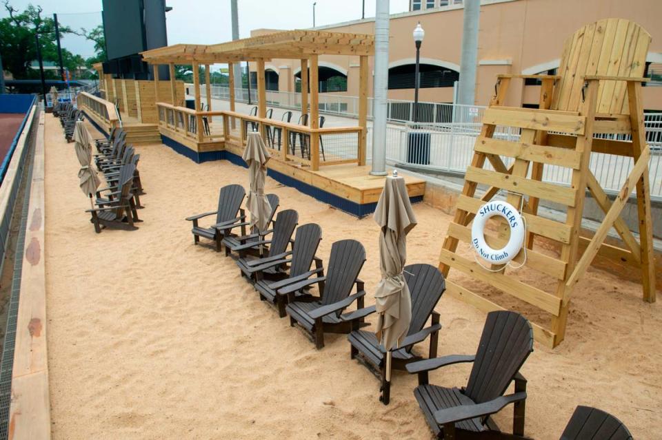 A sandy beach with Adirondack chairs and other additional seating on what was the grassy berm at Shuckers Ballpark on Friday, May 10, 2024.