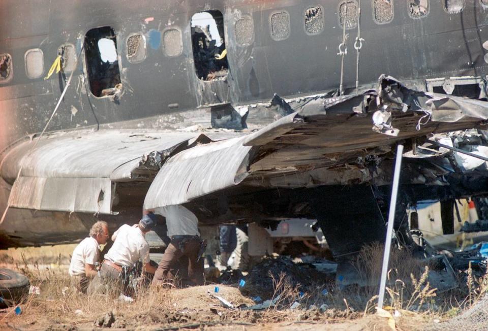 Aug. 31, 1988: Three investigators examine a portion of the destroyed wing of Delta Flight 1141, a Boeing 727 that crashed that morning during takeoff at Dallas-Fort Worth International Airport.