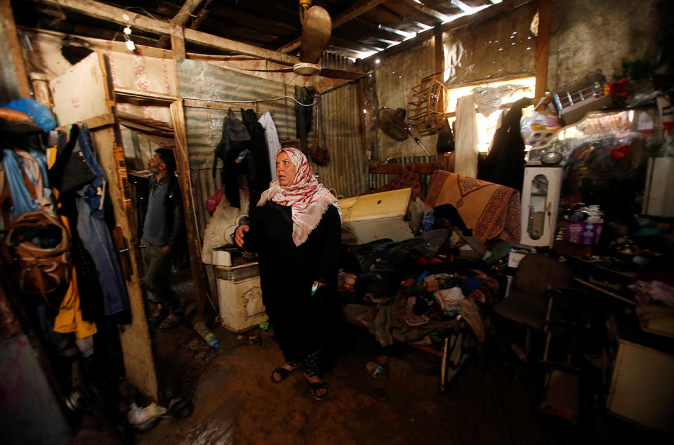 A Palestinian woman inspects flood damage