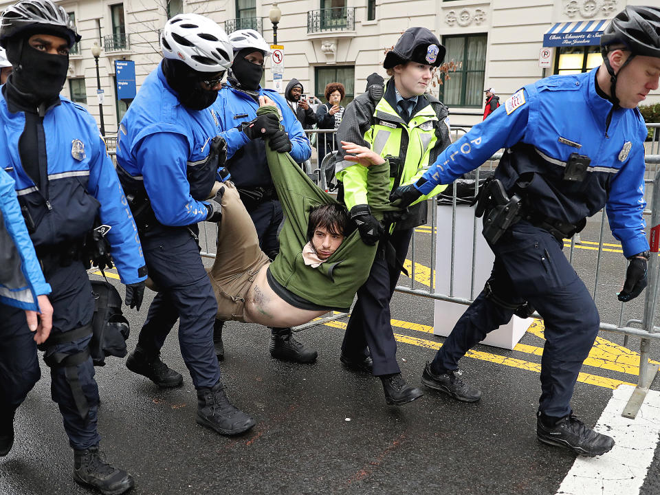 A protester is dragged away from a public access point to the National Mall on 14th Street NW prior to the inauguration in Washington DC: Getty