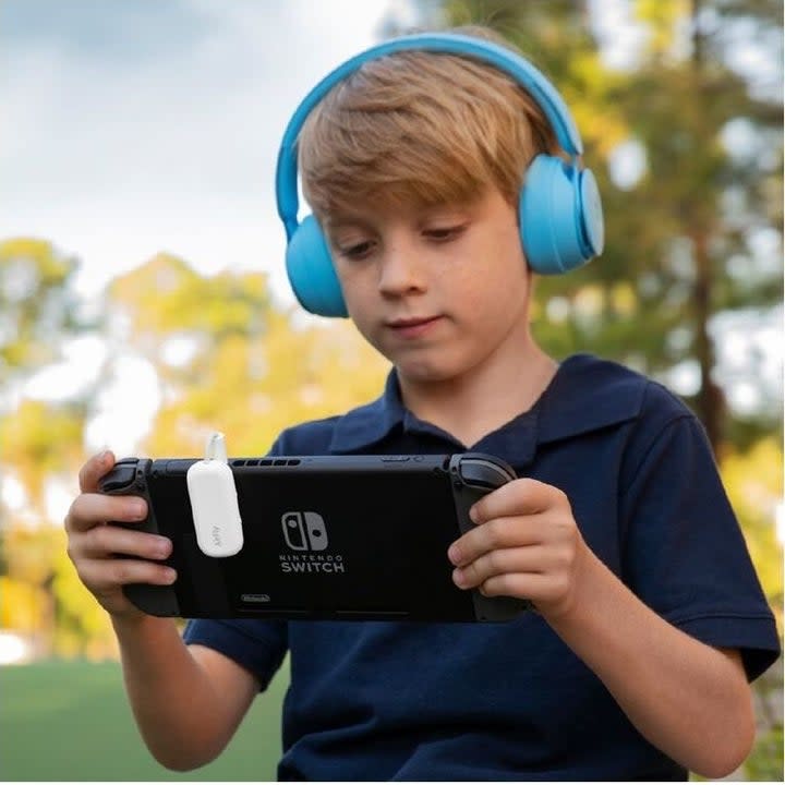 a child using the transmitter for headphones to play video games