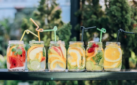 Row of party fruit and vegetable infused drinks and straws