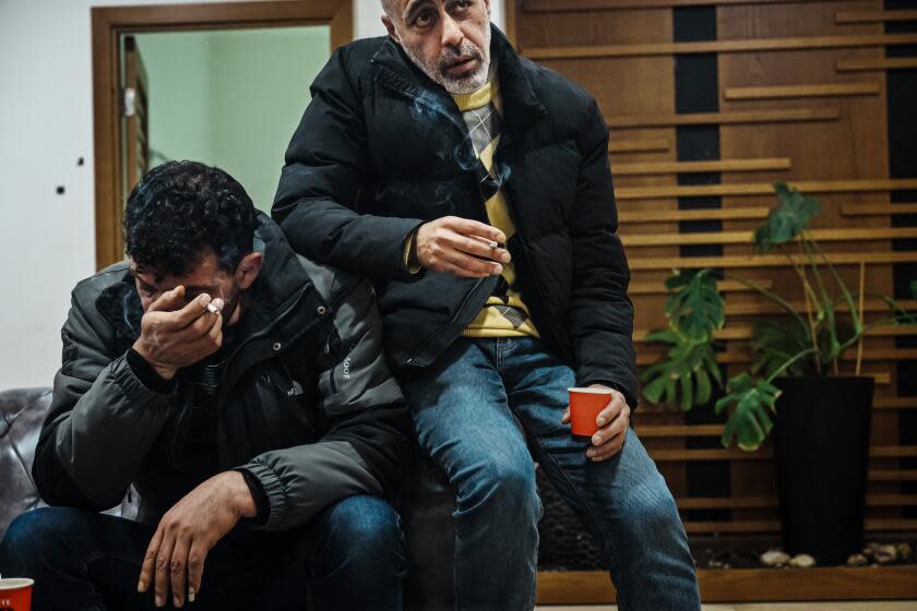 RAMALLAH, OCCUPIED WEST BANK -- FEBRUARY 14, 2024: Ahmad Abu Alezz, left, and Mohammad Al-Farra, right, spend their evenings watching the TV news and smoking, commiserating about the war in Gaza from Ramallah, Occupied West Bank , Wednesday, Feb. 14, 2024. Both men are originally from Gaza, and have known each other for years. Both have families who are trapped there. But the purgatory of this war D and a shared sense of impotence D has brought them closer. OWe calm each other down,O said Al Farra, who said they do so with emotional support but also an ample dose of black humor. OIt makes it easier.O (MARCUS YAM / LOS ANGELES TIMES)