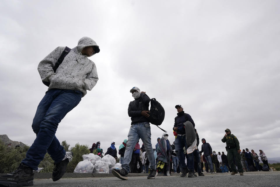 A group of migrants line up as they wait to apply for asylum after crossing the border, Wednesday, May 10, 2023, near Jacumba, Calif. The group have been camping just across the border for days, waiting to apply for asylum in the United States. The Biden administration on Thursday will begin denying asylum to migrants who arrive at the U.S.-Mexico border without first applying online or seeking protection in a country they passed through, marking a fundamental shift in immigration policy as the U.S. readies for the end of a key pandemic restriction. (AP Photo/Gregory Bull)