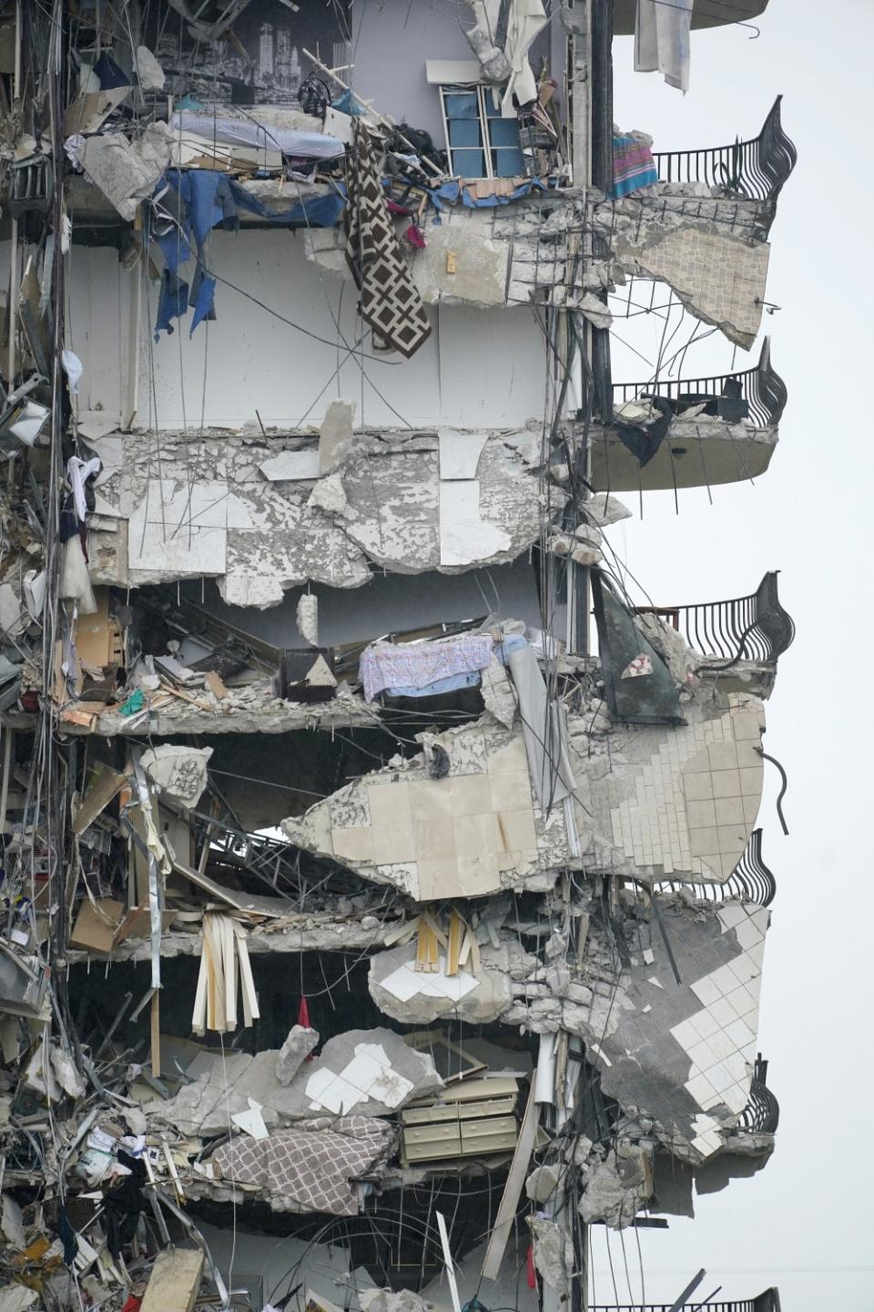 Multiple stories are shown with bent balconies, shredded walls and flooring hanging in midair.