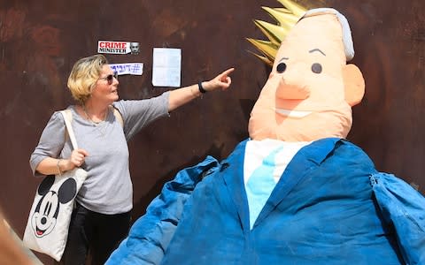 A woman points at a doll made to resemble Israel's Prime Minister Benjamin Netanyahu in Tel Aviv, Israel, Sunday, April 7, 2019 - Credit: &nbsp;Ariel Schalit/&nbsp;AP