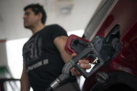 Wallace Reid fuels his vehicle he drives to make a living using ride-share apps, Wednesday, June 22, 2022, in the Queens borough of New York. Millions of Americans who rely on their cars for work are changing their habits, signing up for carpools or even ditching their cars for bicycles as gas prices recently hit $5 per gallon for the first time ever. (AP Photo/John Minchillo)