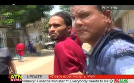 Police lead a suspect away after militants attacked Bangladeshi police guarding an Eid festival in Kishoreganj town in this still frame taken from video July 7, 2016. Courtesy of ATN News /via REUTERS TV