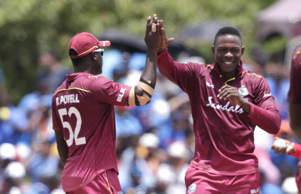 West Indies' Sheldon Cottrell, right is congratulated by Rovman Powell, left, after taking the wicket of India's Virat Kohli during the first Twenty20 international cricket match, Saturday, Aug. 3, 2019, in Lauderhill, Fla. (AP Photo/Lynne Sladky)