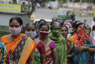 Indian women wear face masks as a precaution against coronavirus stand in queue to submit their form to update their details to receive benefits of government schemes at Beedi Workers Welfare Hospital in Ahmedabad, India, Friday, July 24, 2020. India is the third hardest-hit country by the pandemic in the world after the United States and Brazil. (AP Photo/Ajit Solanki)