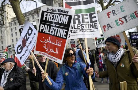 Demonstrators hold placards as they protest against Israel's Prime Minister Benjamin Netanyahu's visit, opposite Downing Street in London, Britain, Fberuary 6, 2017. REUTERS/Dylan Martinez