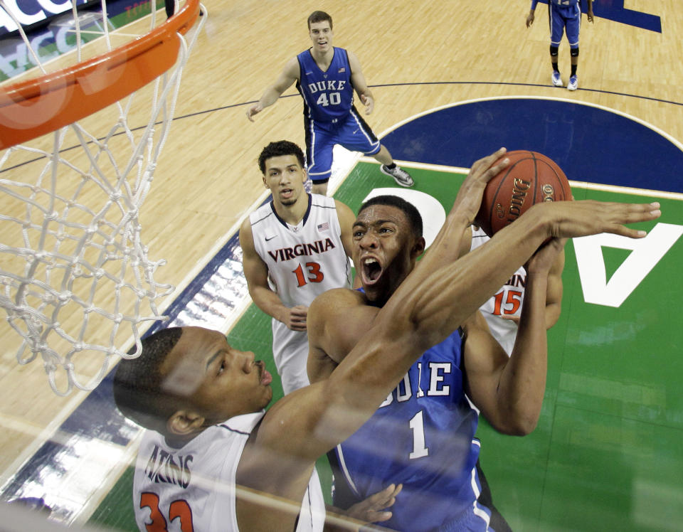 FILE - In this March 16, 2014 file photo, Duke's Jabari Parker (1) tries to shoot over Virginia's Darion Atkins during the first half of an NCAA college basketball game in the championship of the Atlantic Coast Conference tournament in Greensboro, N.C. Parker says he plans to meet with Duke coach Mike Krzyzewski when he returns to Durham, N.C., on Tuesday, April 15, 2014, and he will decide Wednesday whether to declare for the NBA draft or return to college for his sophomore year. (AP Photo/Bob Leverone, File)