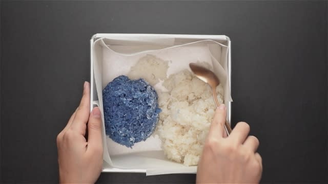 Mixing blue and white rice in baking tin