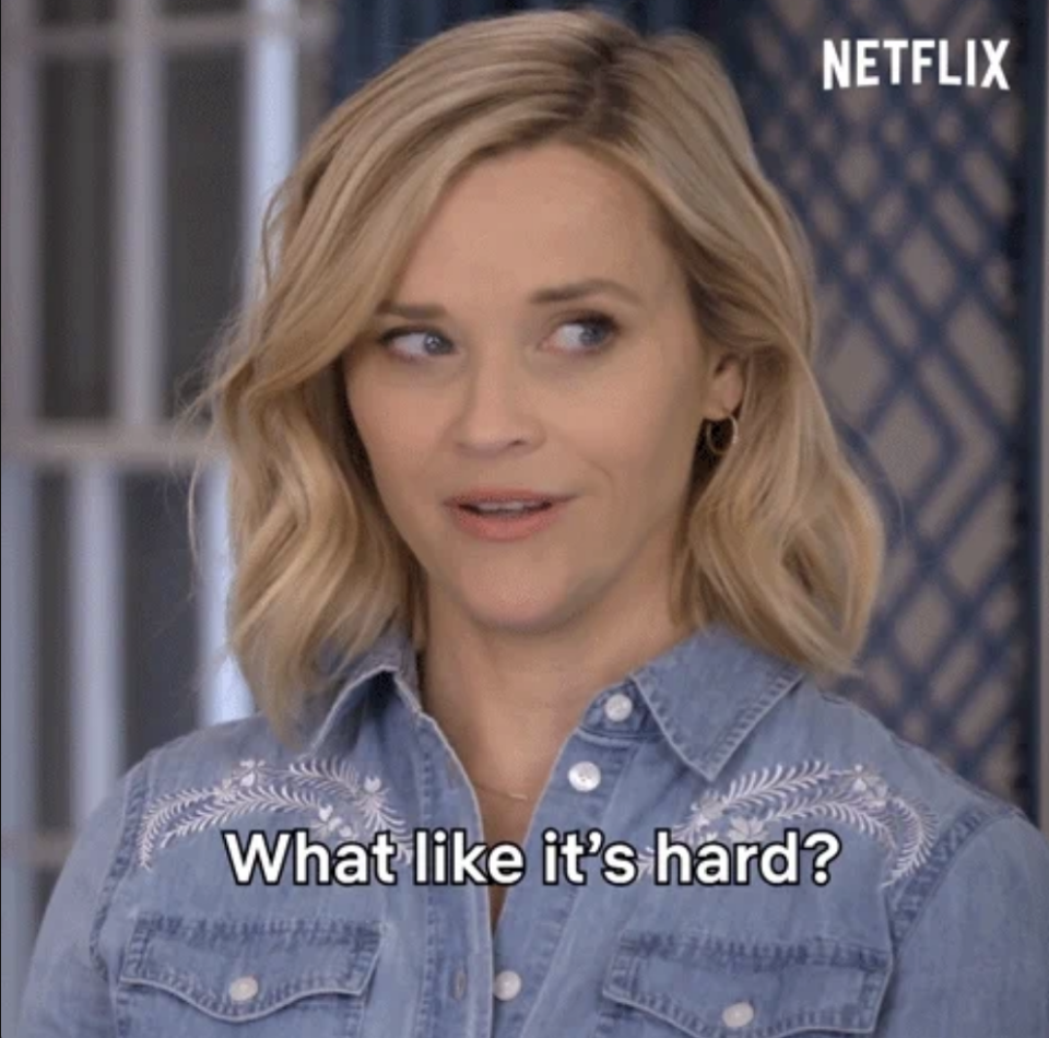 Reese Witherspoon with short blonde hair, wearing a denim shirt with embroidery. Text on image: "What like it's hard?"