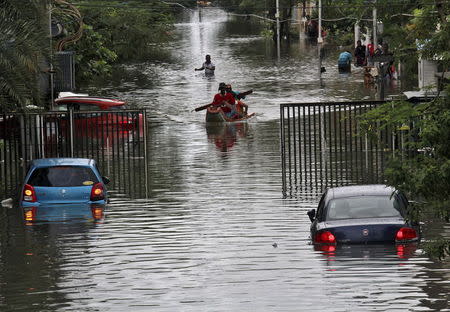 People travel on a boat as they move to safer places through a flooded road in Chennai, December 2, 2015. REUTERS/Stringer