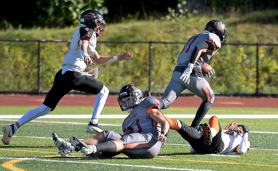 Uxbridge's Liam Rigney, right, powers his way into the end zone for a first half touchdown against Oxford.