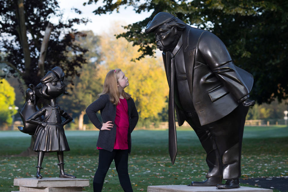 Mollie Sutton, eight, from Romford takes a look at a statue of Roald Dahl’s Matilda which was unveiled in Great Missenden in Buckinghamshire, alongside one of President Donald Trump, to celebrate the 30th Anniversary of Matilda the novel. (David Parry/PA Wire/PA Images)